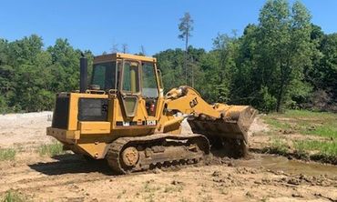 Backhoe Digging Soil — Foristell, MO — Wildschuetz Bros. Trucking Inc Backhoe Digging Soil — Foristell, MO — Wildschuetz Bros. Trucking Inc