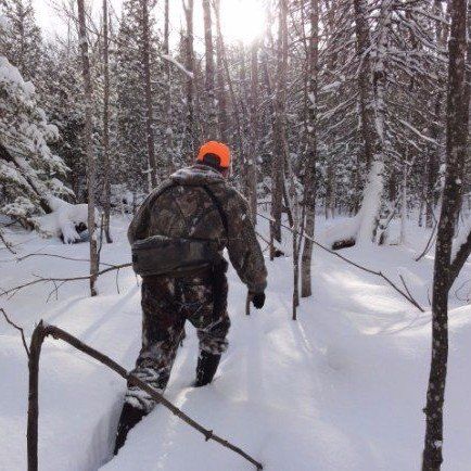 Photo of a hunter hiking through the forest