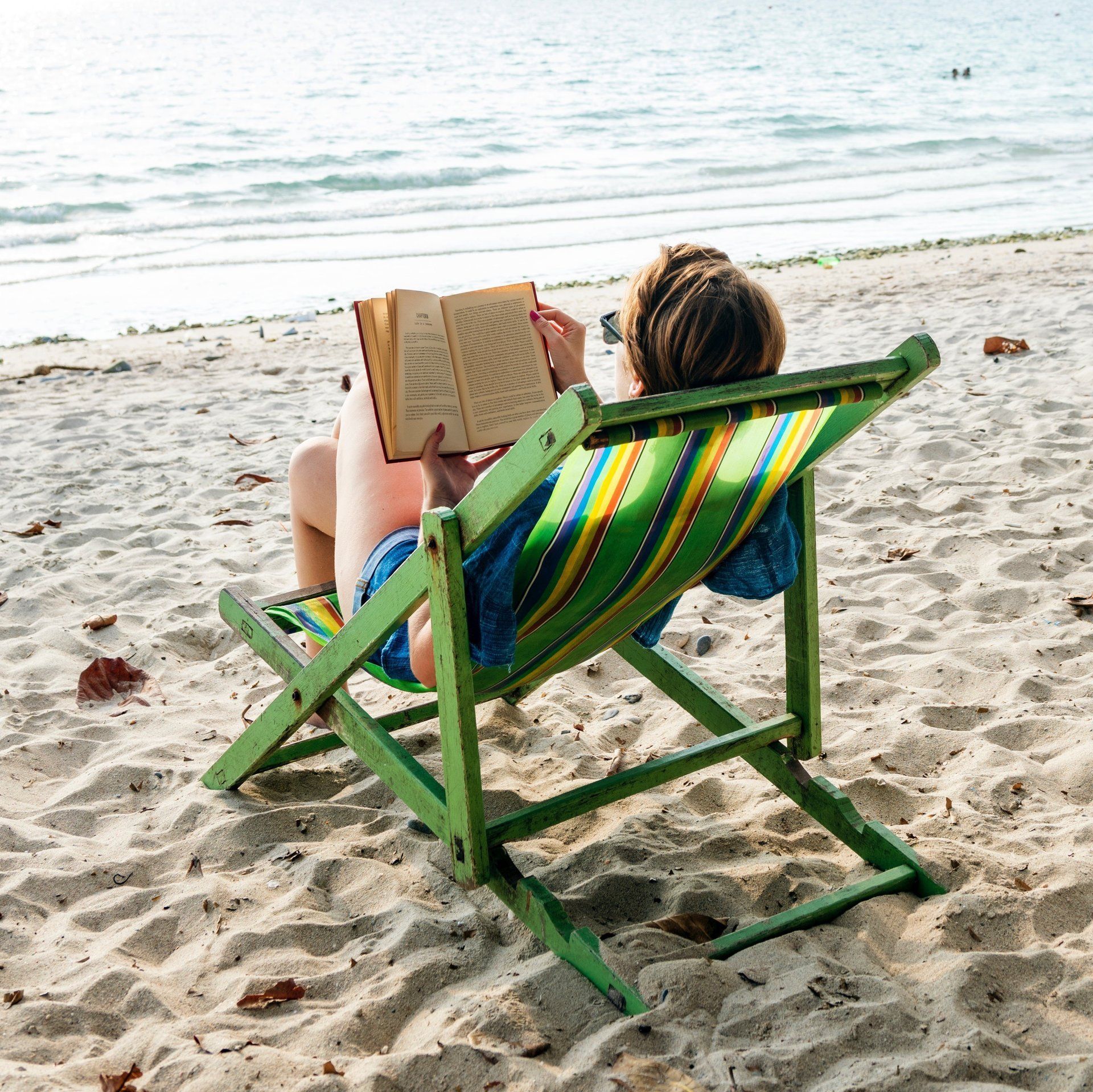 A woman reading a book while sitting on a chair