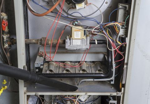 Open electrical panel with wires, breakers, and components exposed inside a metal cabinet