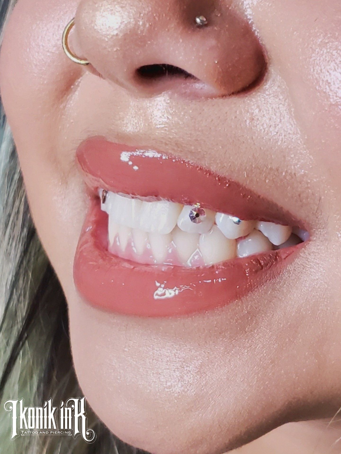 Close-up of a crystal tooth gem on a tooth by Ikonik Ink