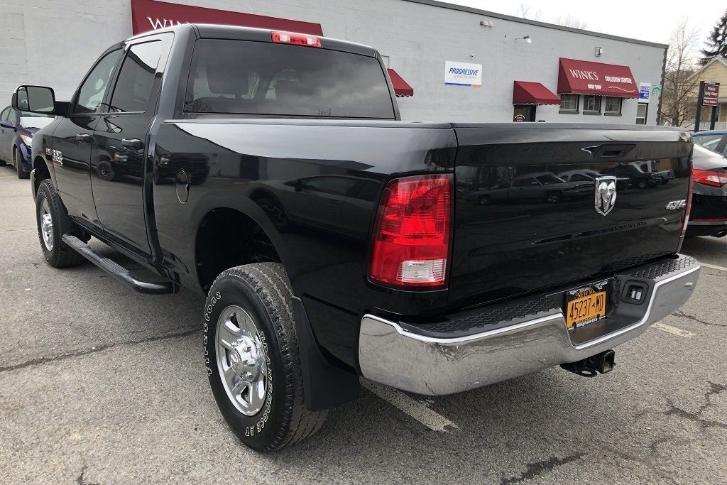 A black dodge ram truck is parked in front of a building.