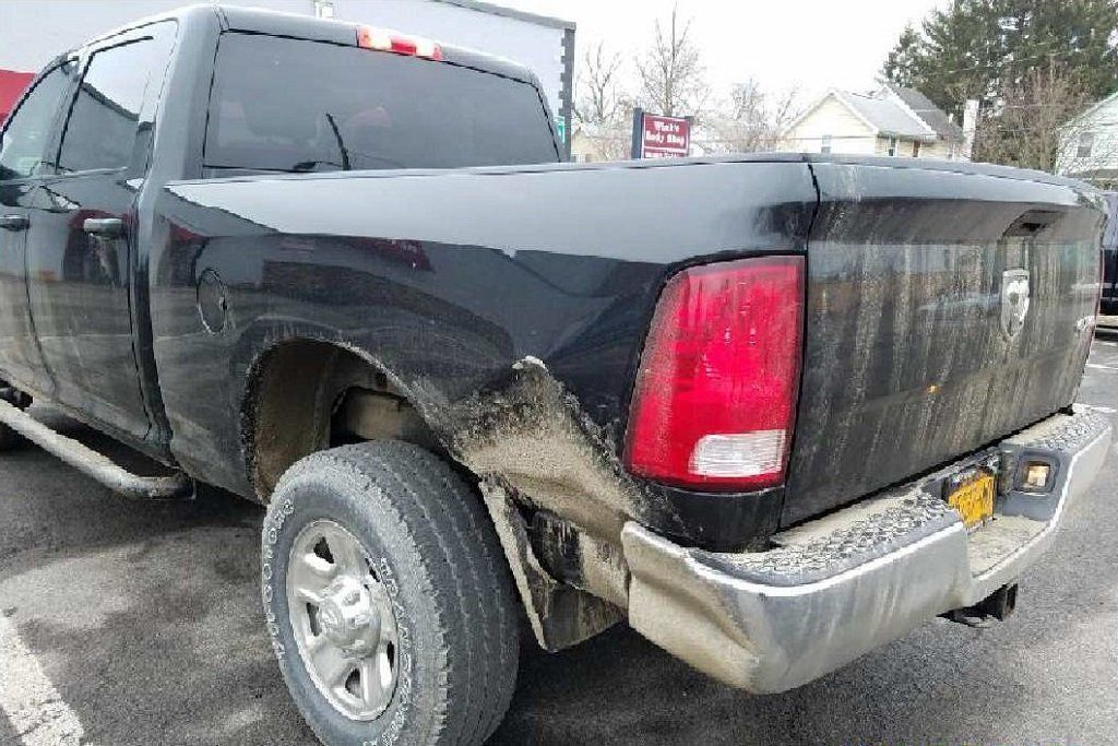 A black dodge ram truck is parked in a parking lot.