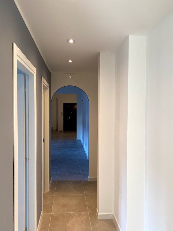 Ristrutturazione corridoio con controsoffitto e faretti LED: ottimizzazione degli spazi e valorizzazione della luce naturale, in un intervento eseguito dal Gruppo Menichini a Roma.