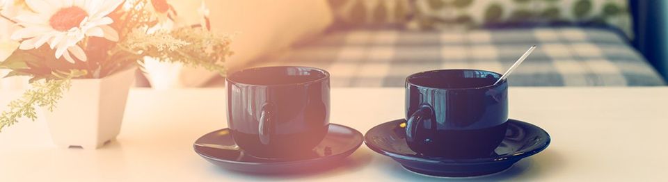 Two cups of coffee on table with flowers | Four Seasons Sales Property Management