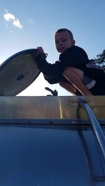 A young boy is looking out of the roof of a vehicle