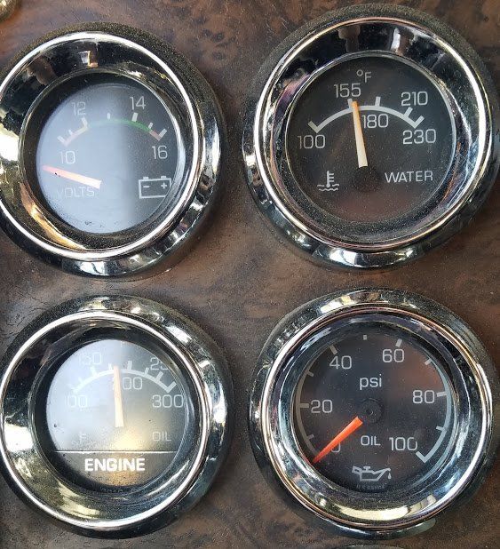 A close up of four gauges including one that says engine