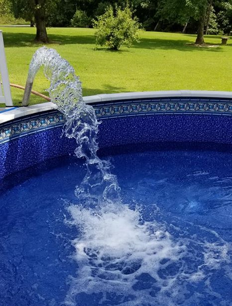 A hose is pouring water into a swimming pool.