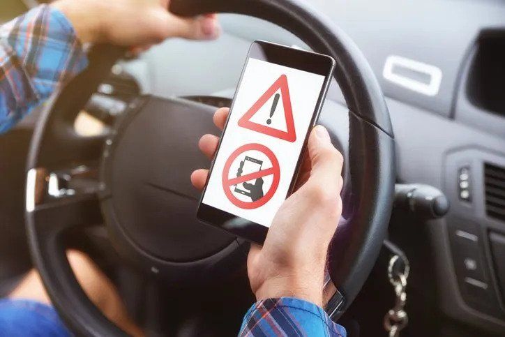 Man Holding Cellphone While Driving — Tucker, Ga — Taggart's Driving School