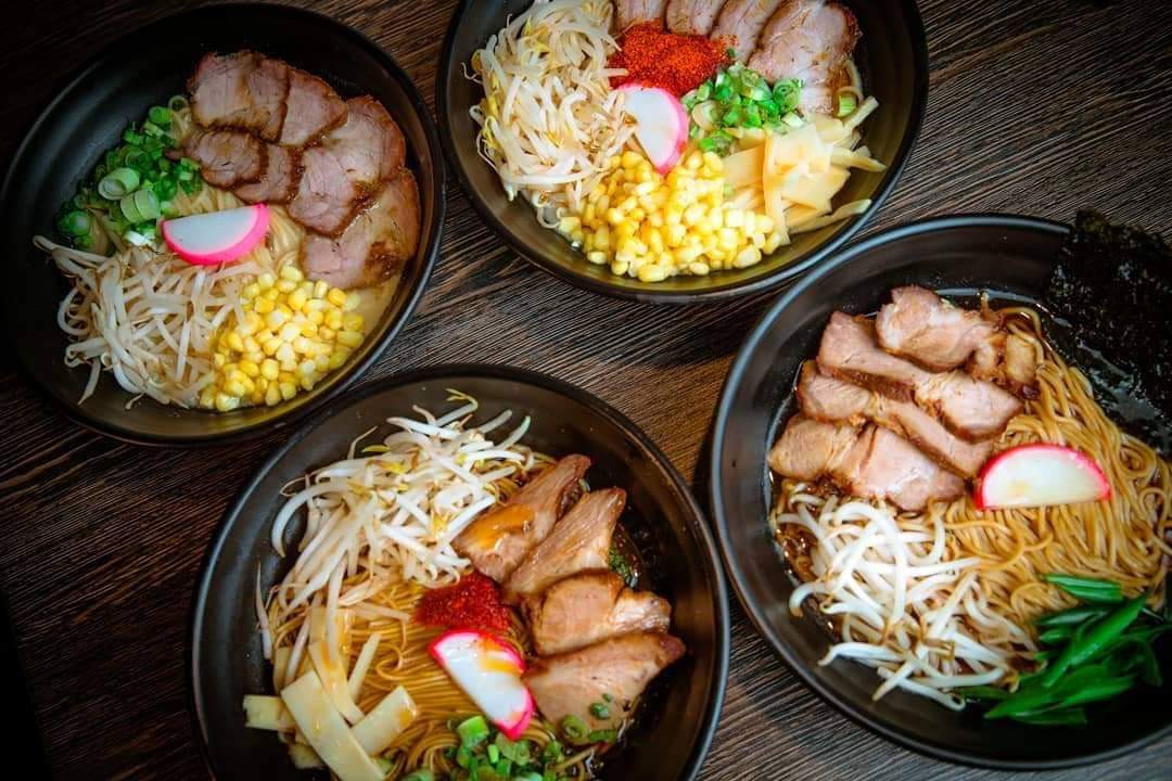 Four bowls of ramen are sitting on a table.