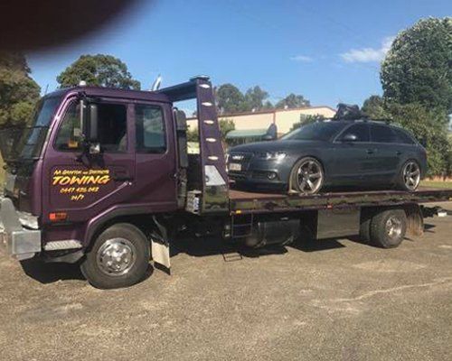 truck carrying black car
