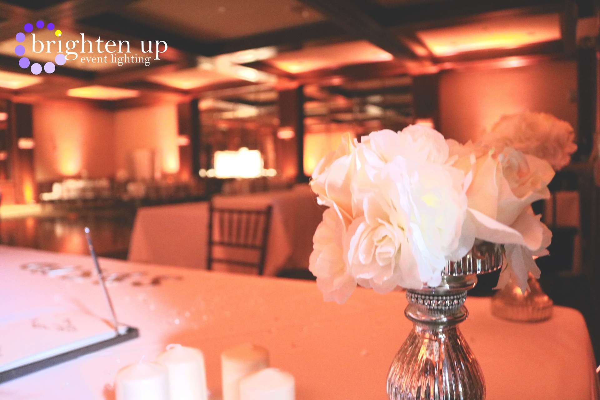 A vase filled with white flowers is on a table.