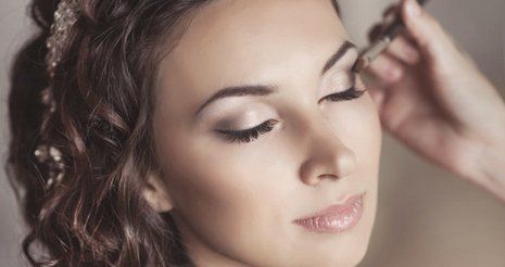 A woman having her her eye makeup applied