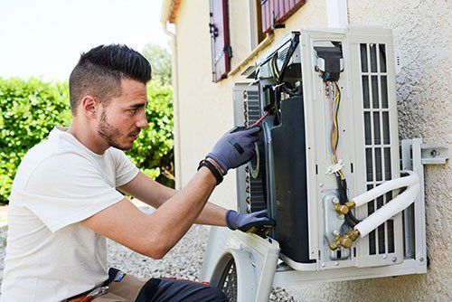 technician working inside air conditioner