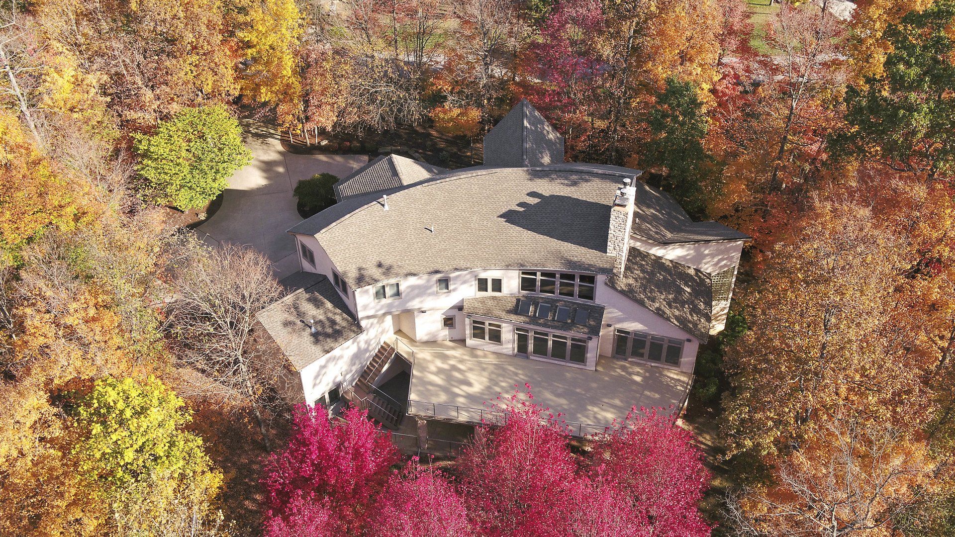 An aerial view of a house in the middle of a forest