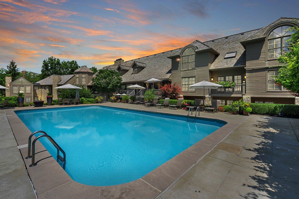 A large swimming pool in front of a row of houses