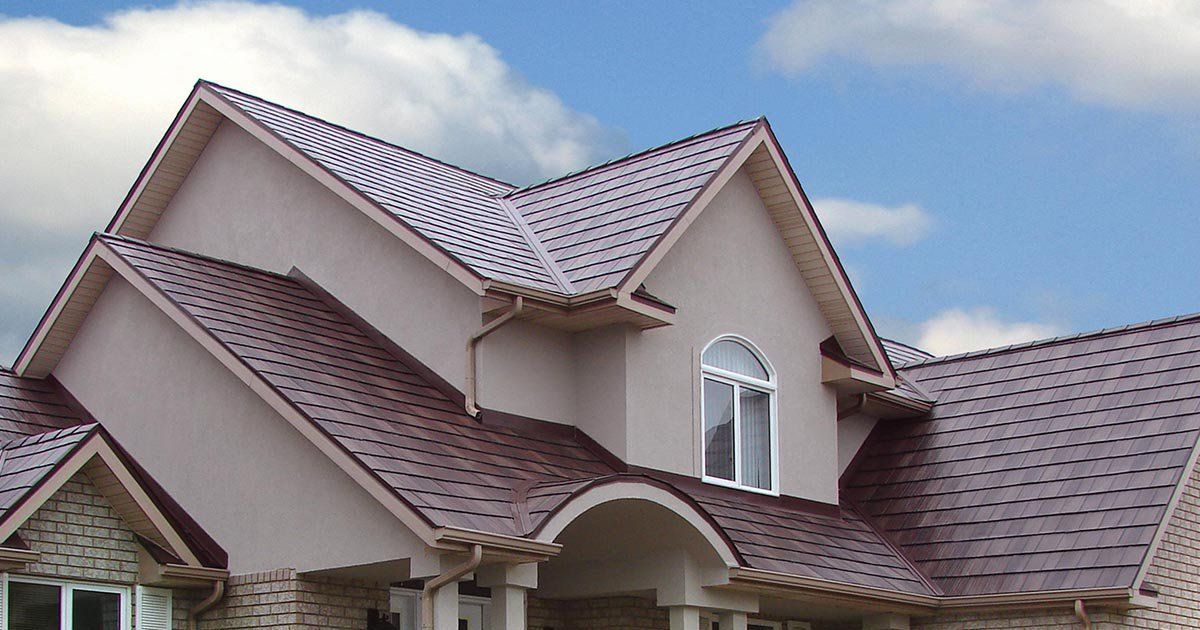 Two-story house with brown tiled roof and arched entryway under construction