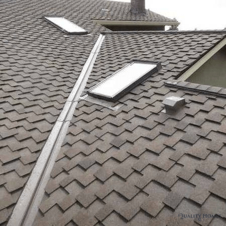 Gray tiled roof with skylights and a long roof valley gutter.