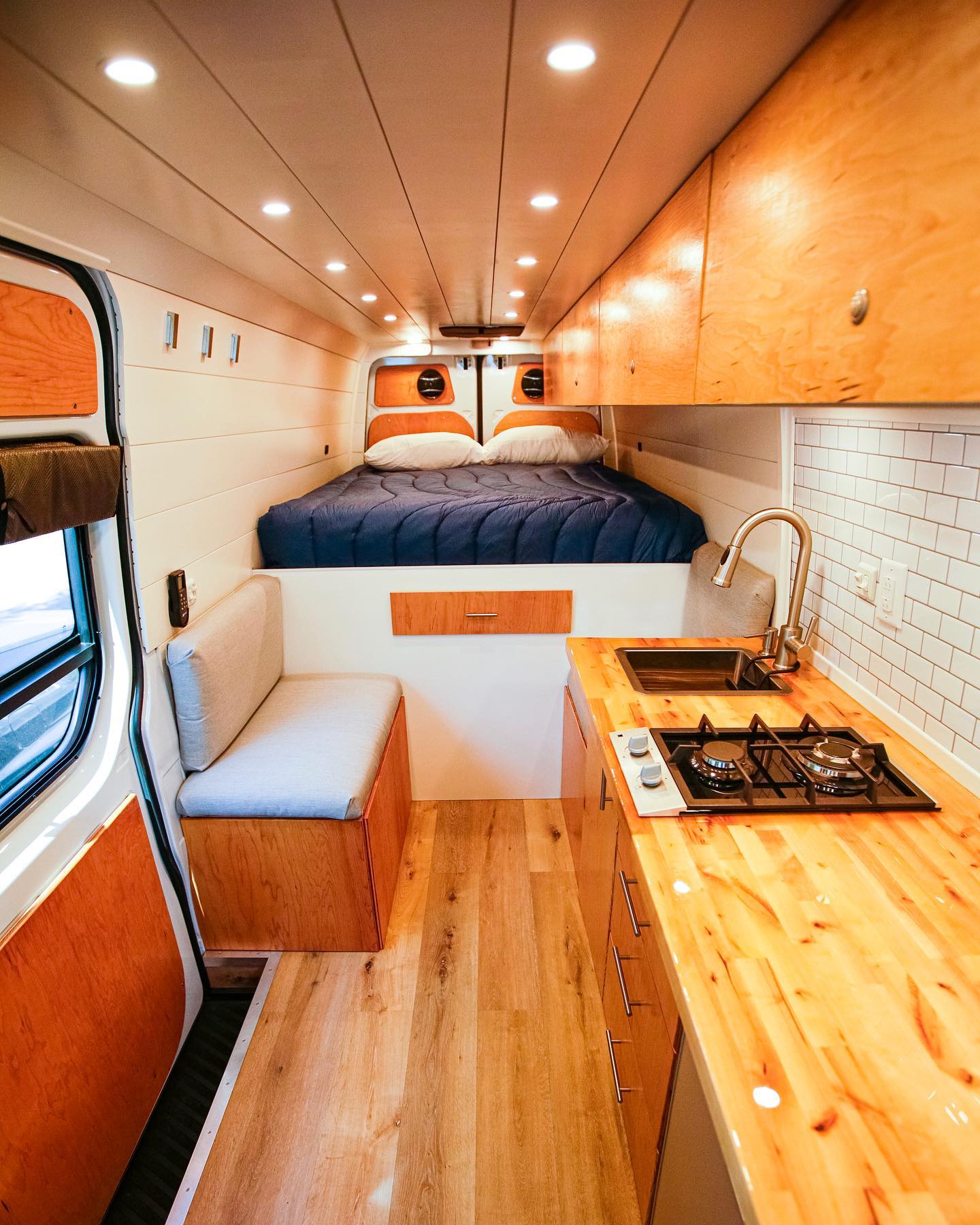 the inside of a van with a bed and a kitchen .