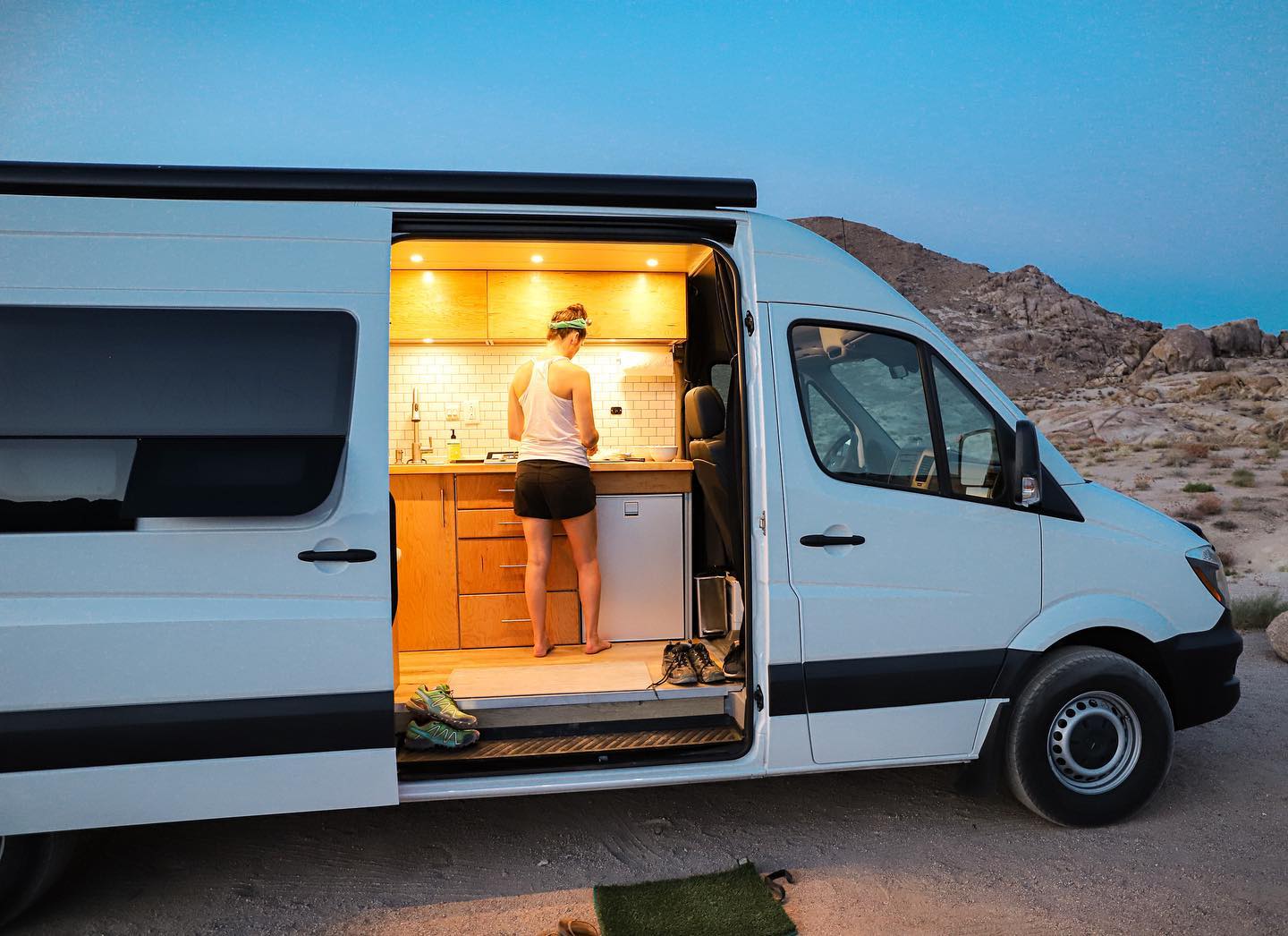 a woman is standing in the kitchen of a van .