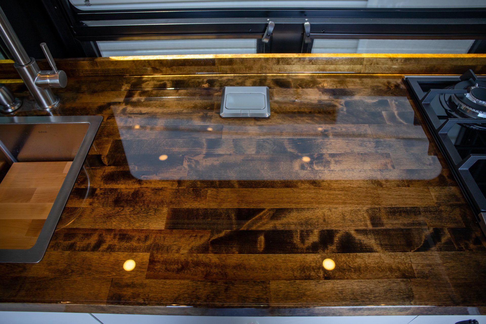 a kitchen counter with a wooden counter top and a stove top oven .