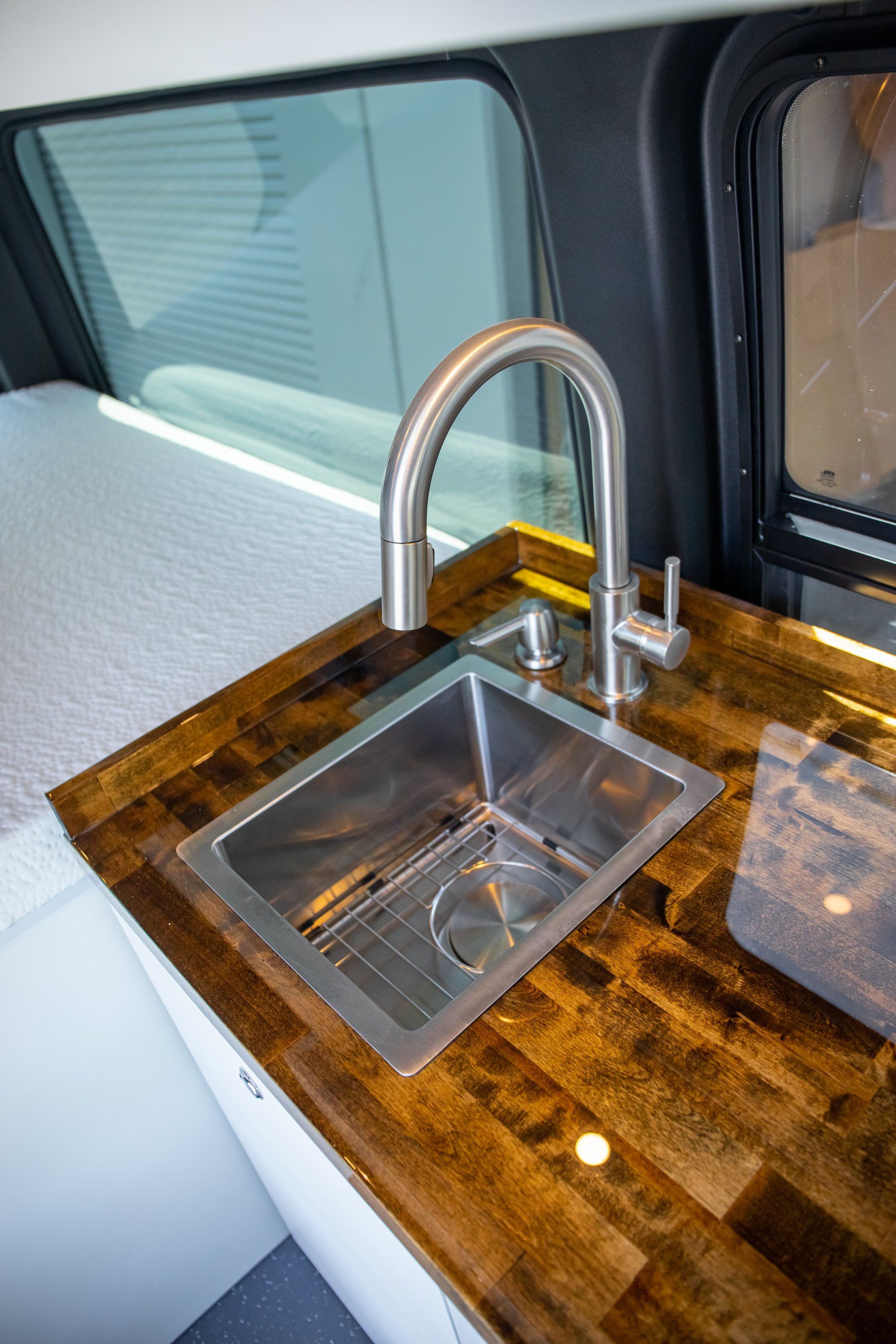 a stainless steel sink is sitting on top of a wooden counter .
