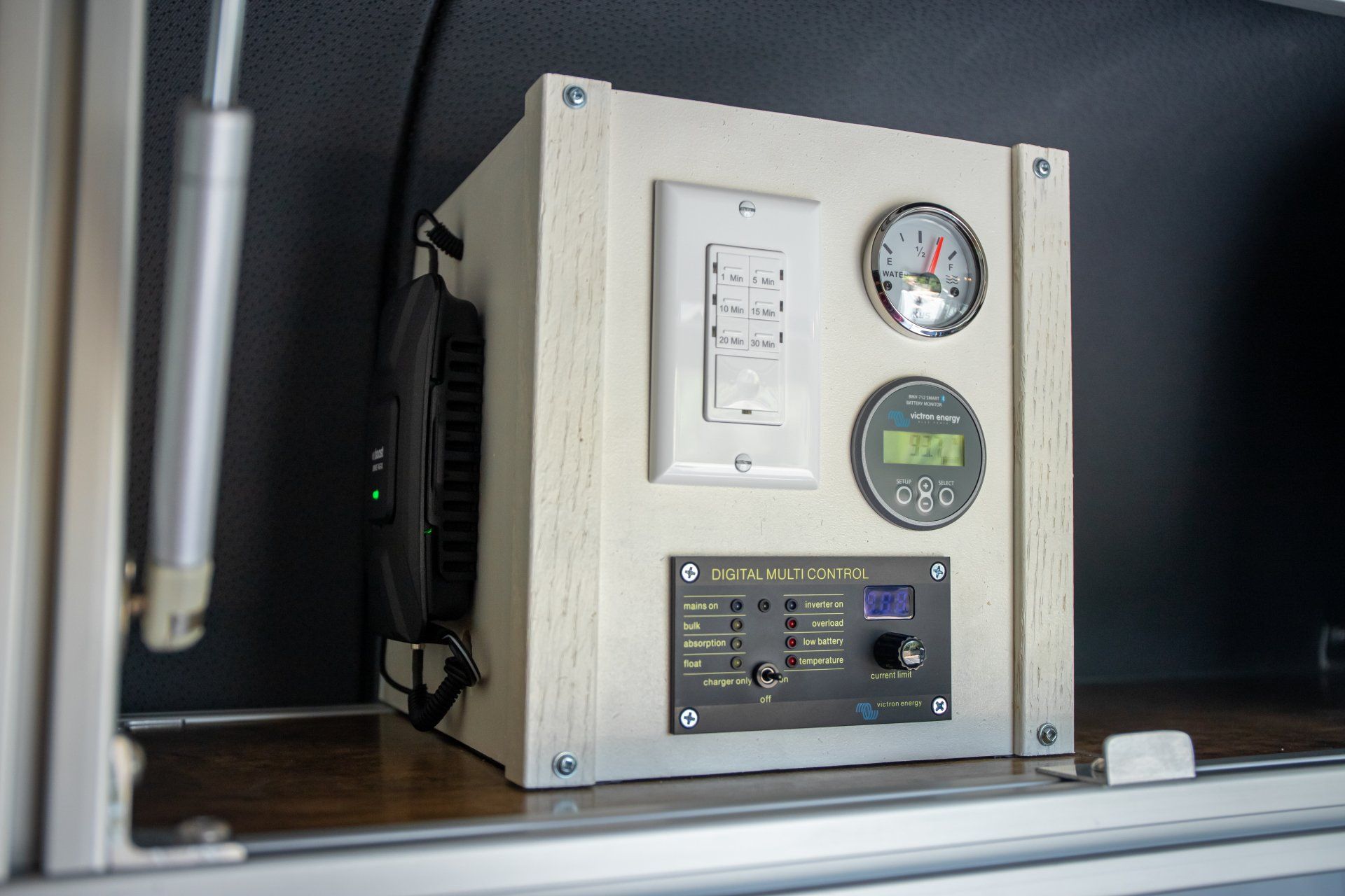 a white box with a clock on it is sitting in a cabinet .