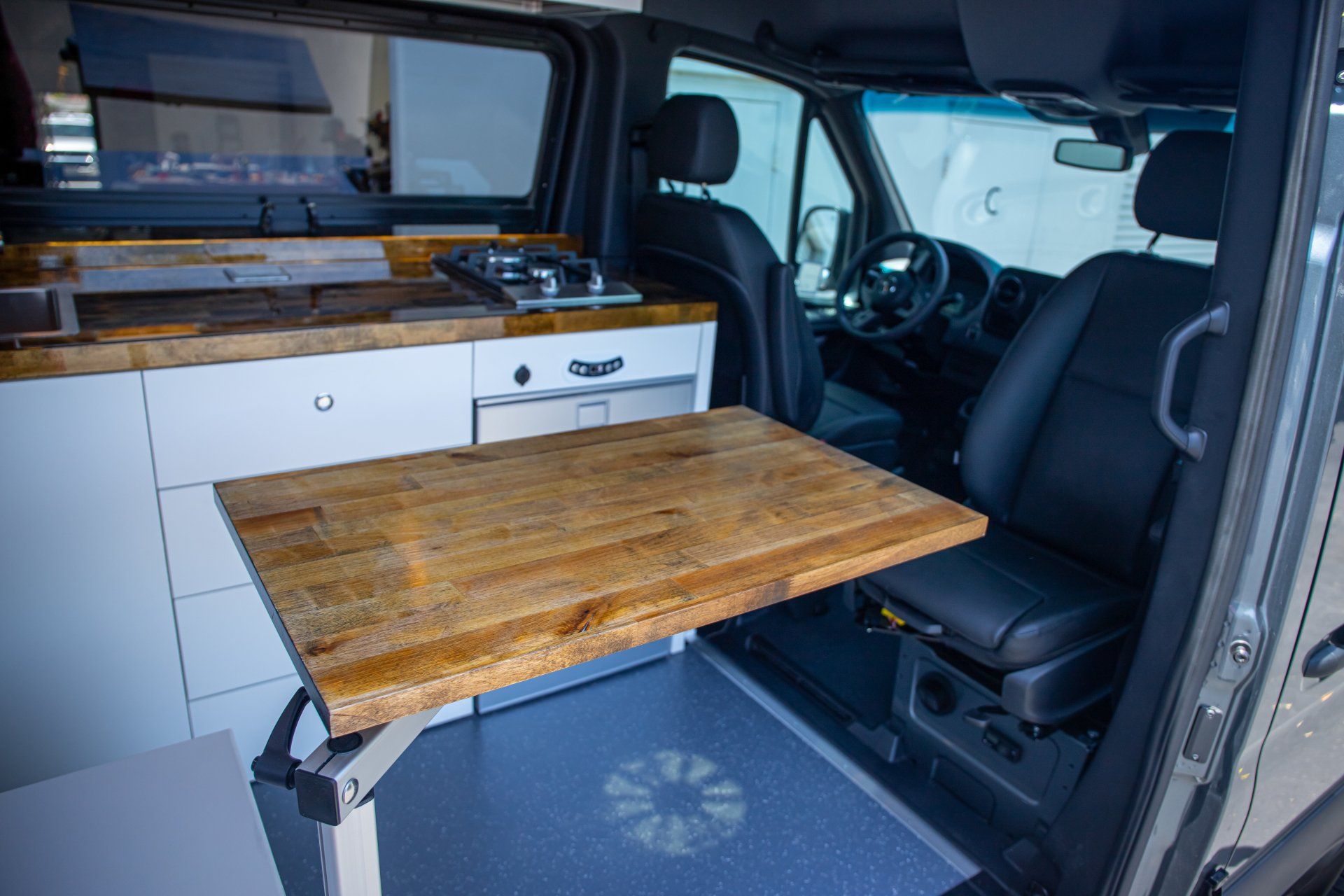 a van with a wooden table that can be pulled out of the seat .