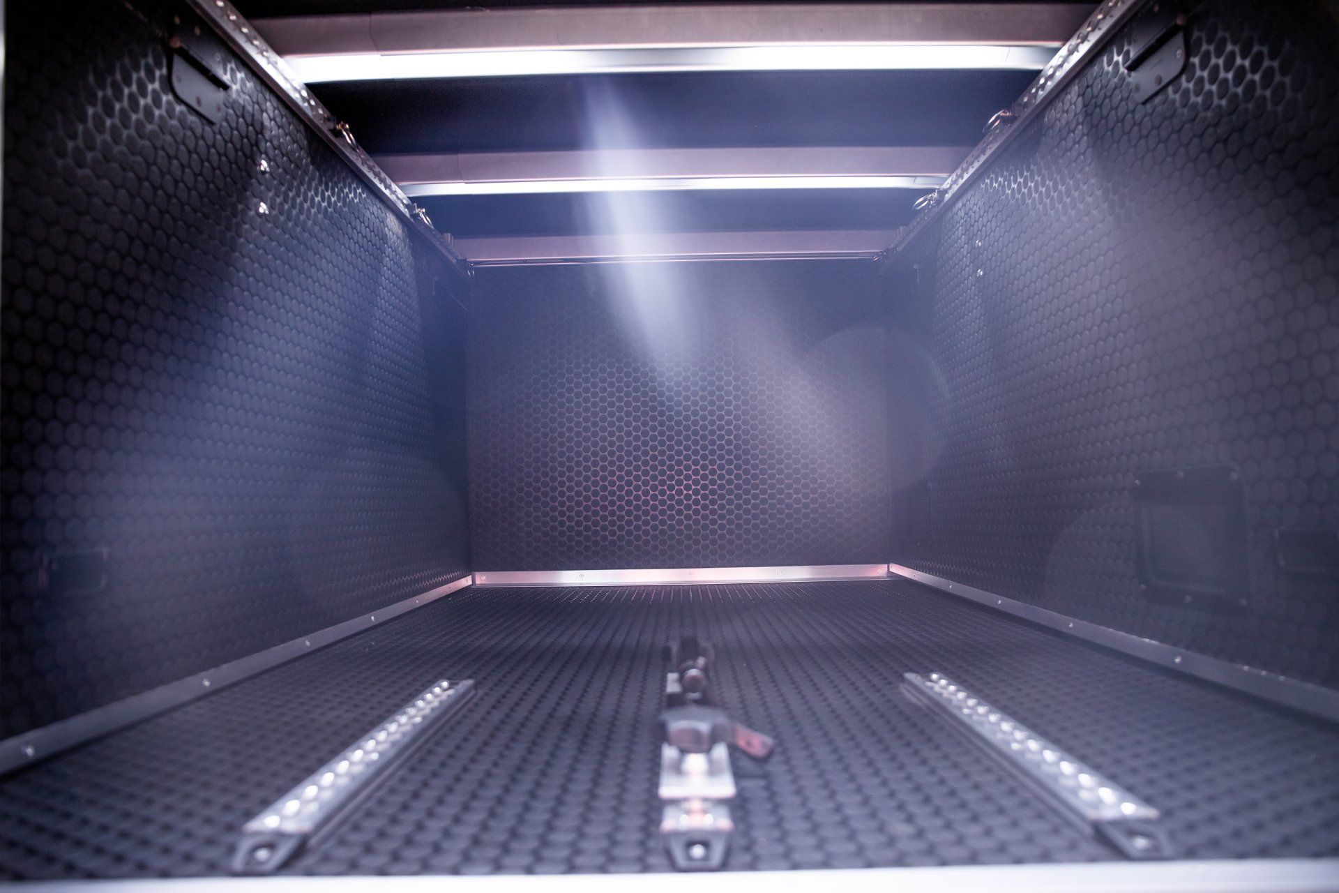 a dark room with a light shining through the ceiling .