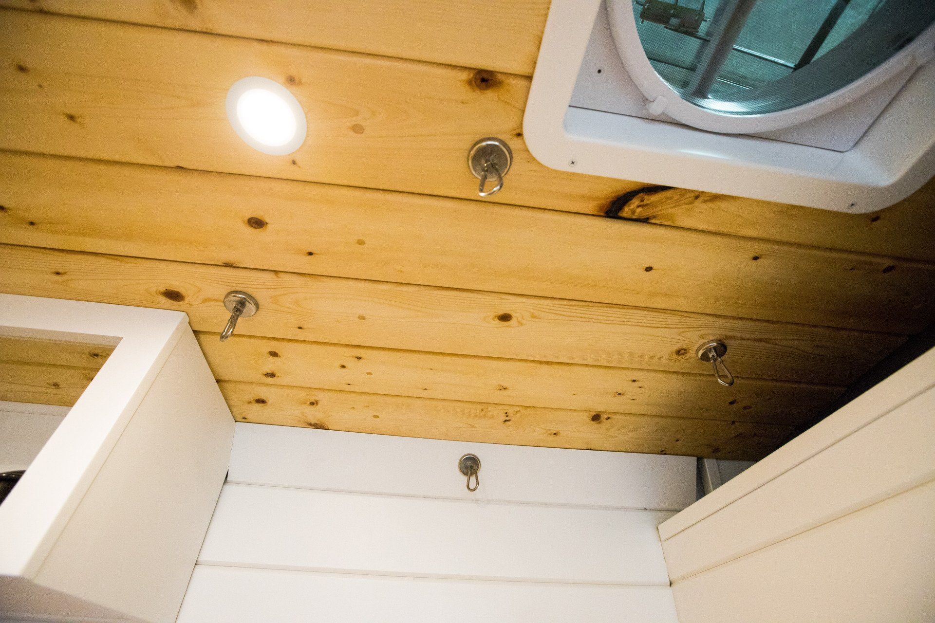 a bathroom with a wooden ceiling and a fan .