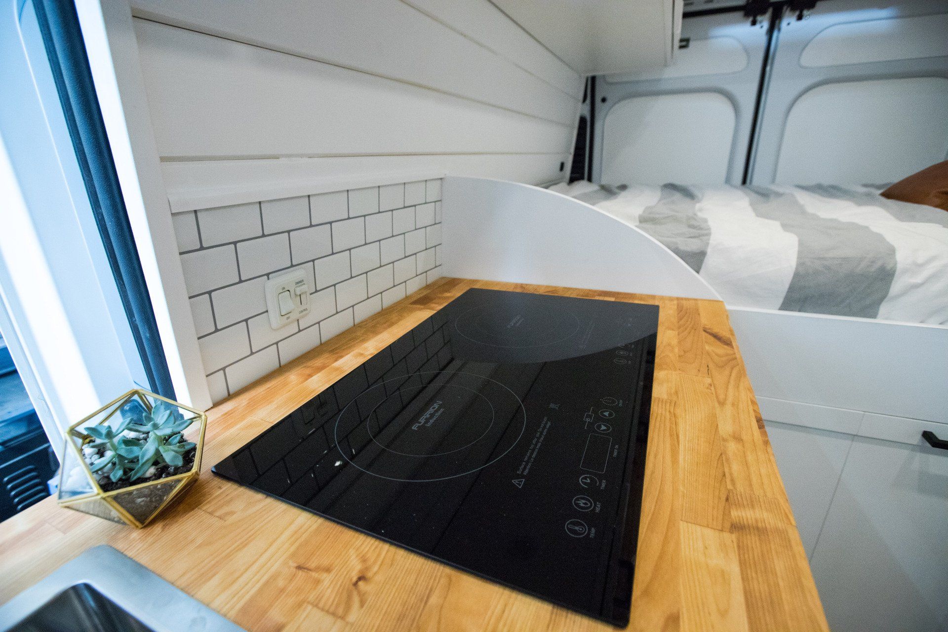 a stove top oven is sitting on a wooden counter in a van .