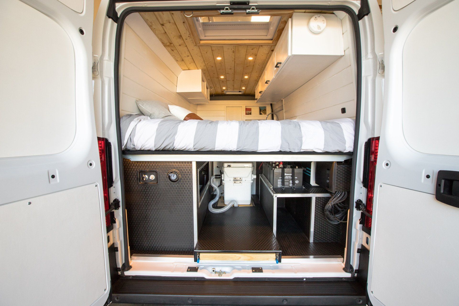 the back of a van with a bed in the back .