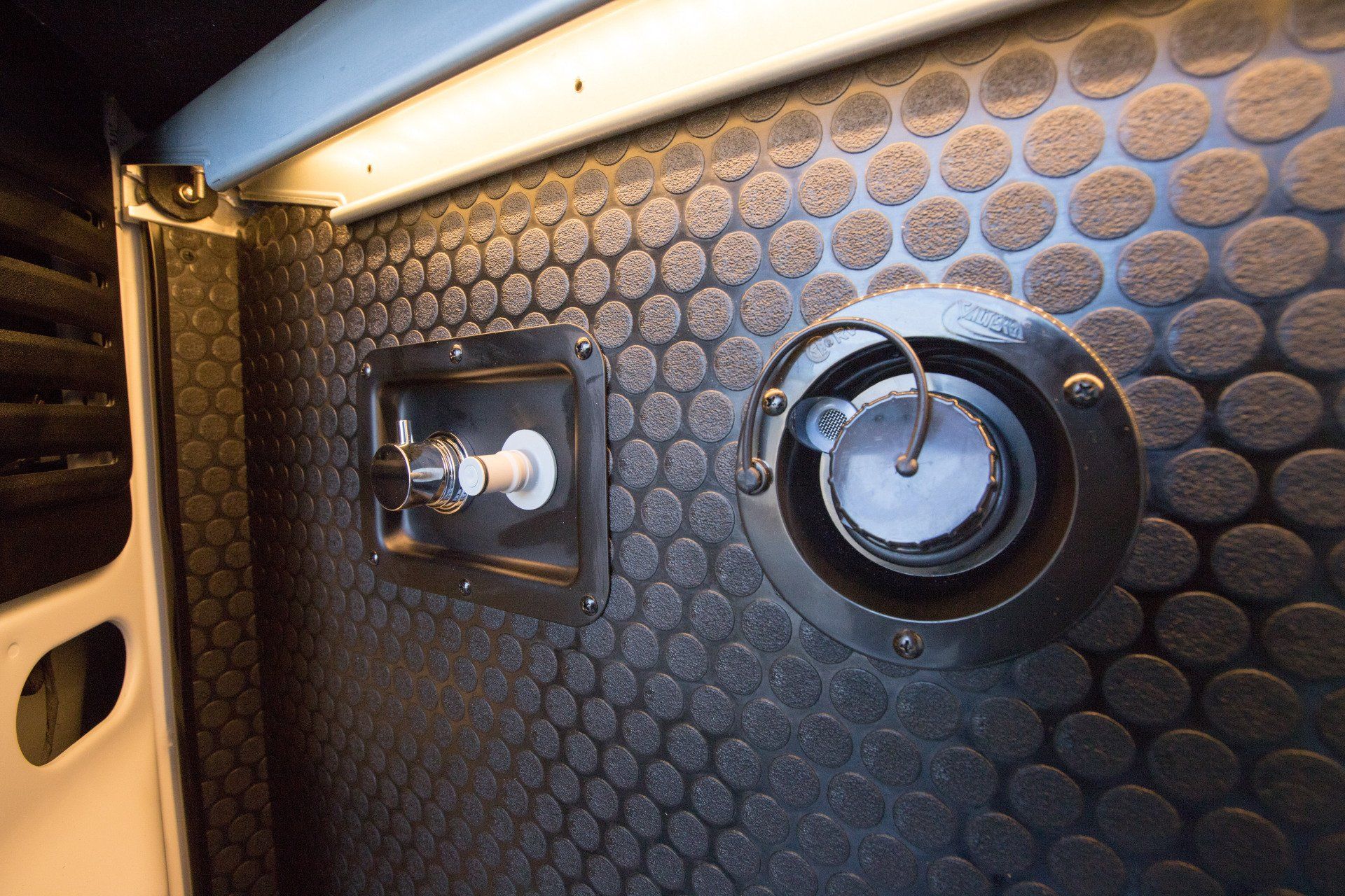 a close up of a fuel tank on a wall in a van .