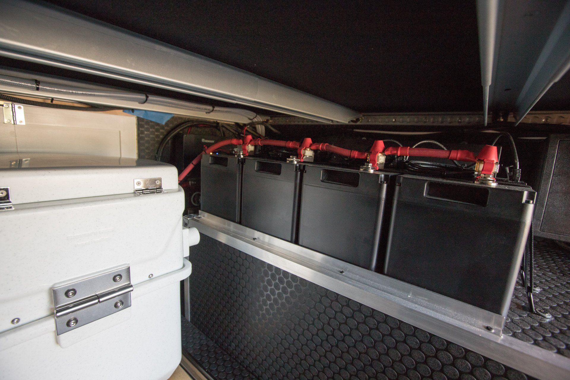 a bunch of batteries are sitting under a shelf in a vehicle .