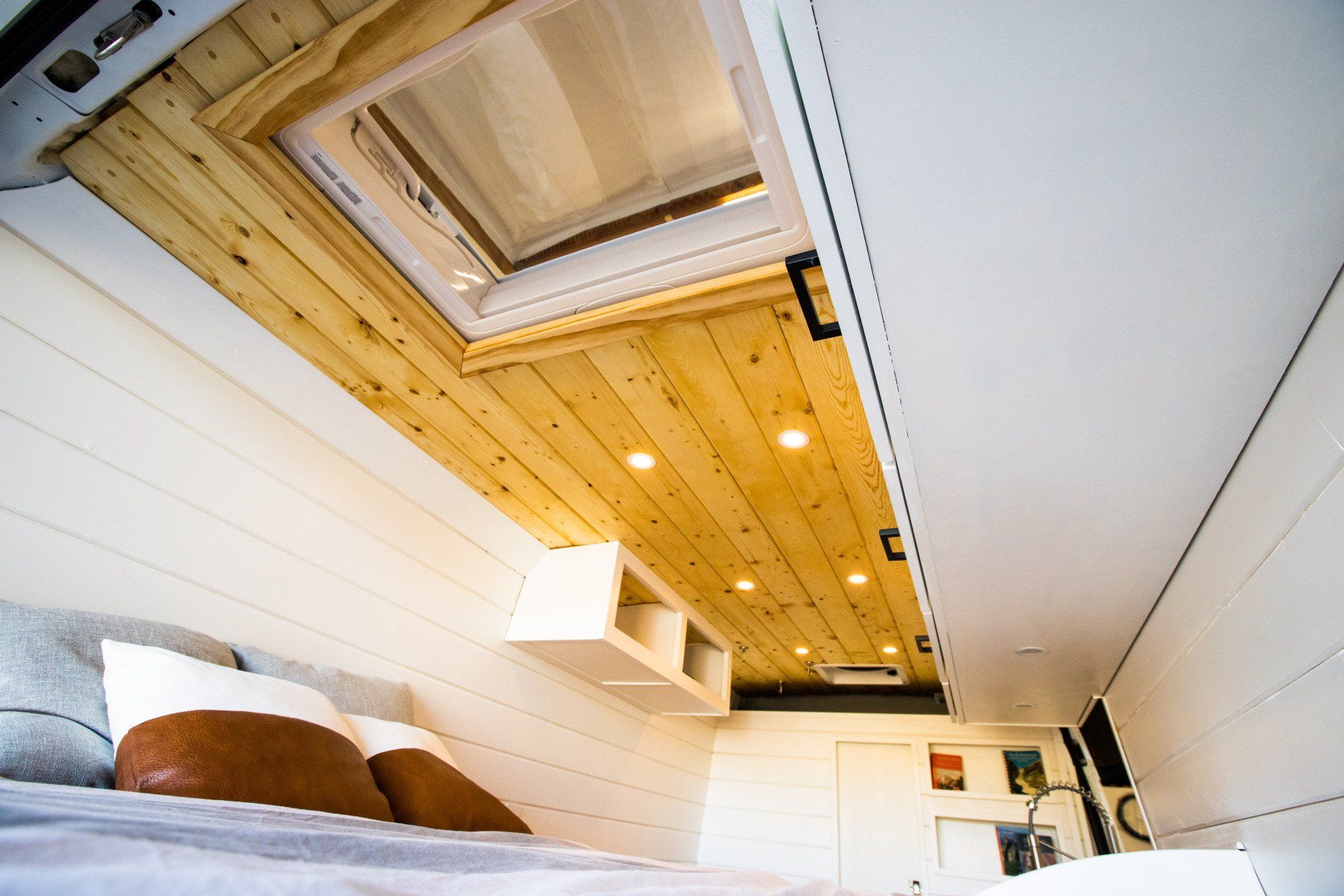 a bedroom with a bed and a skylight in the ceiling .