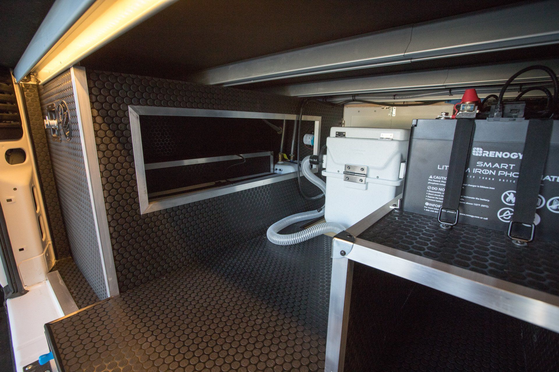 the inside of a van with a bunch of batteries on a shelf