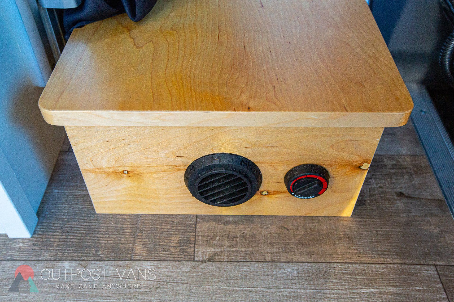 a wooden box with two buttons on it is sitting on a wooden floor .