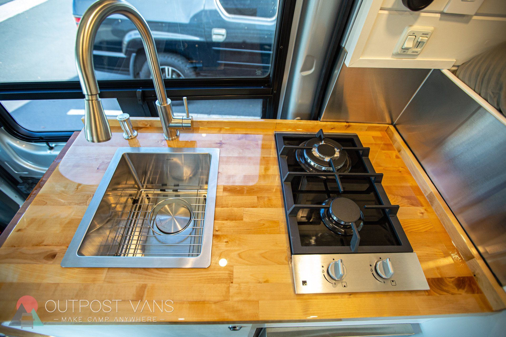 a kitchen in a van with a sink and stove top oven .
