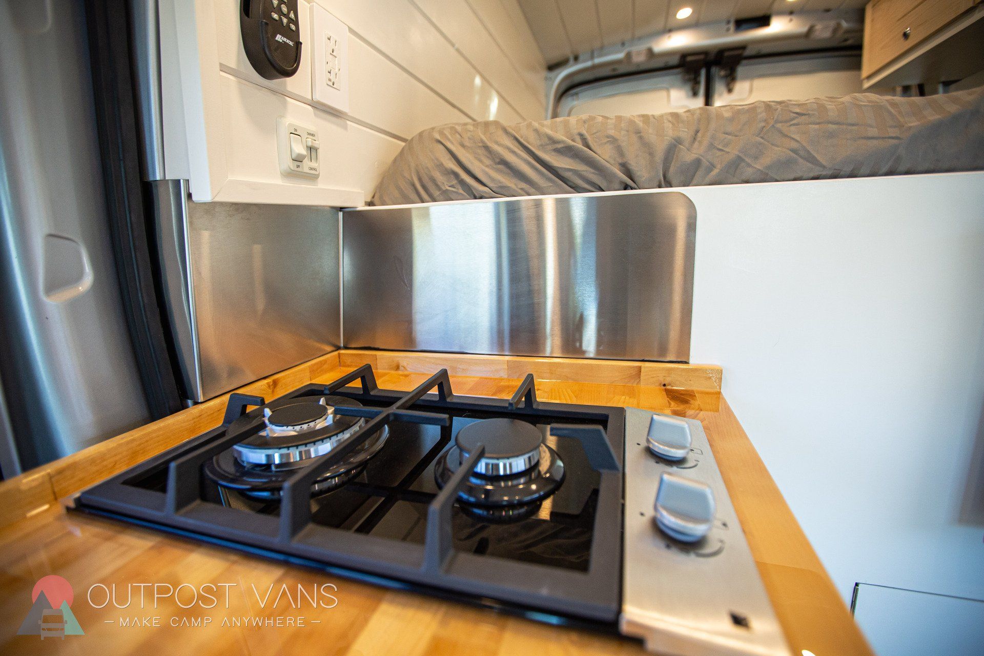 a stove top oven is sitting on top of a wooden counter in a van .