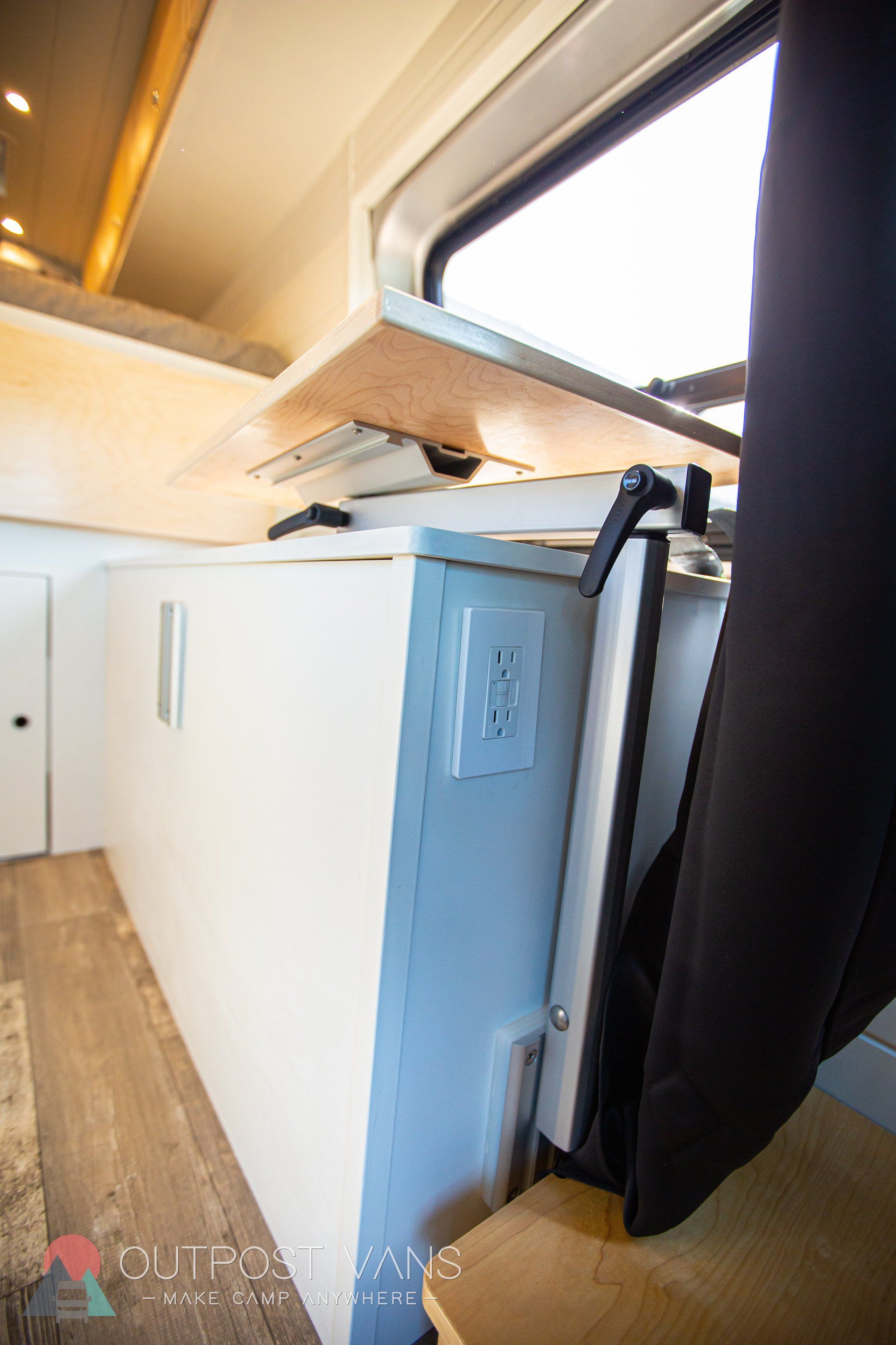 a refrigerator is sitting under a window in a camper van .