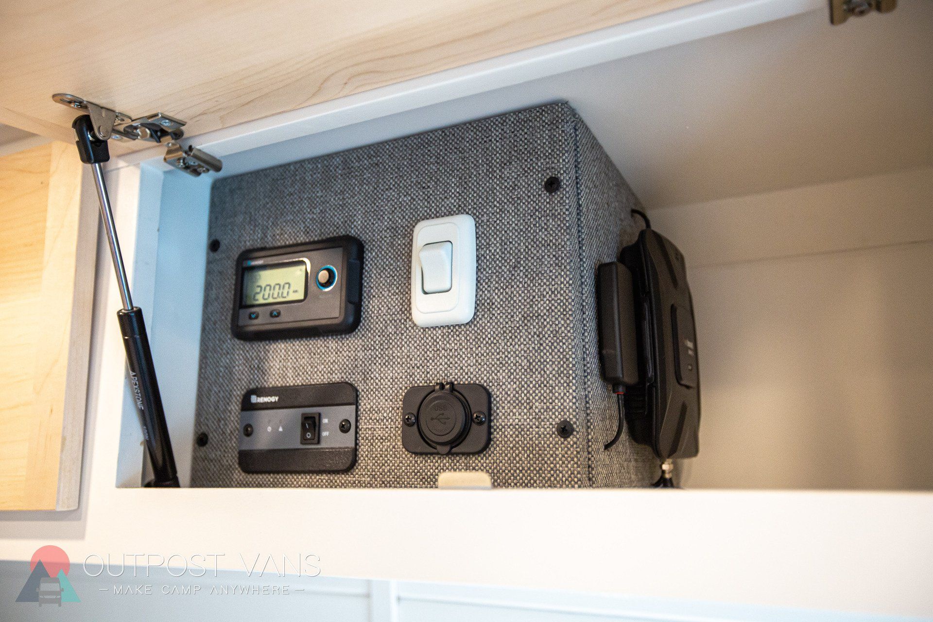 a gray box is sitting under a cabinet in a room .