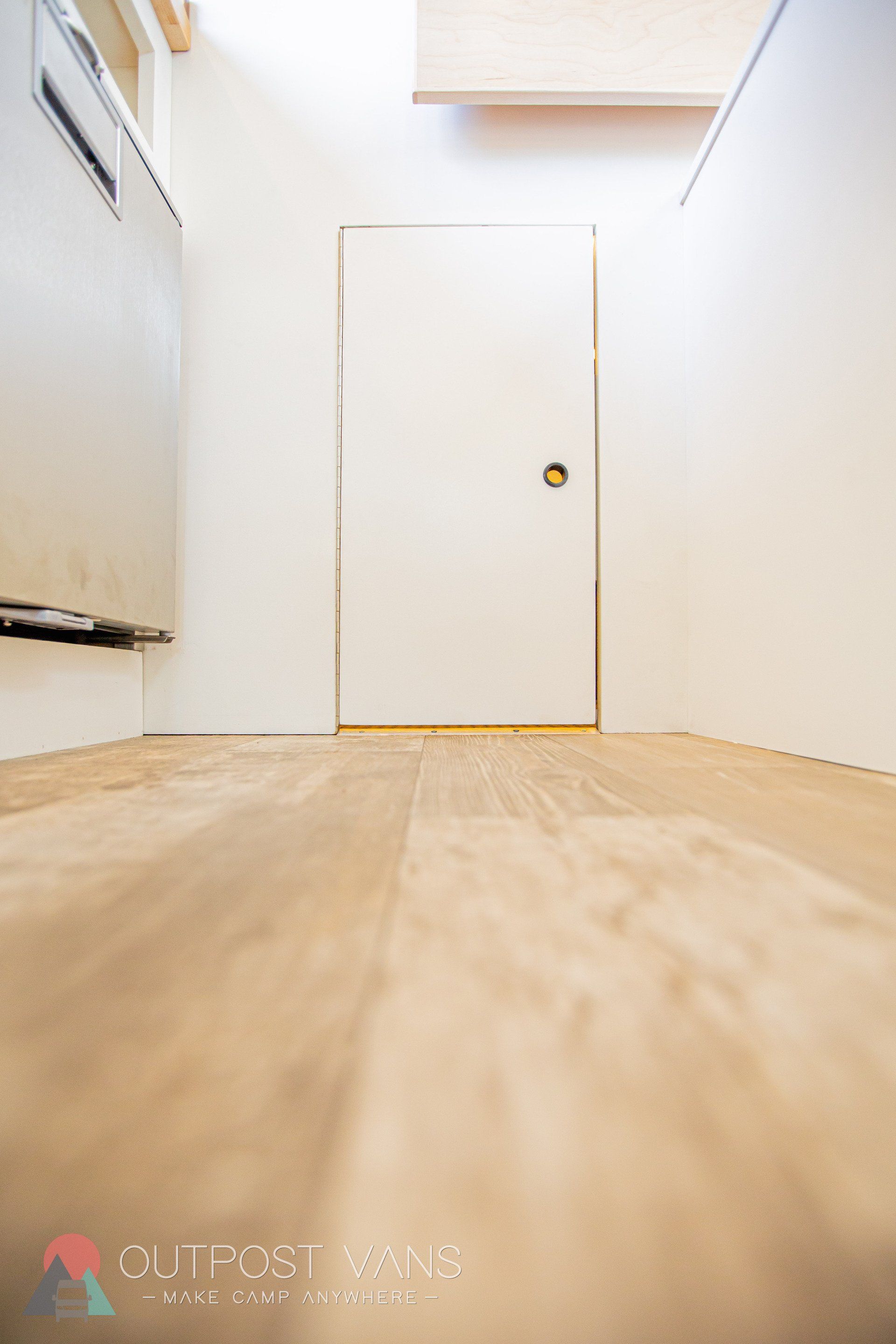 a hallway with a wooden floor and a white door .
