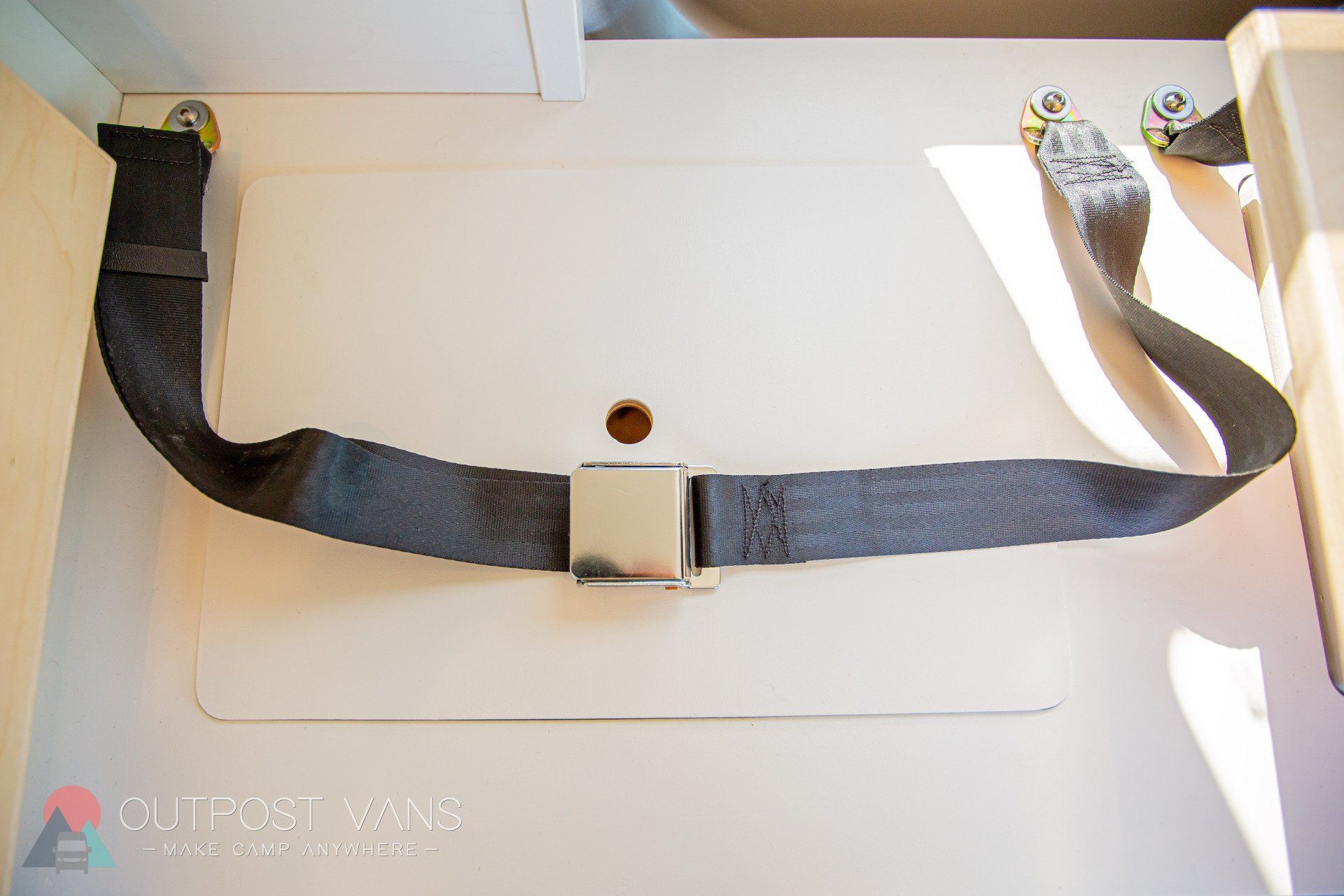 a black seat belt is sitting on a white surface .