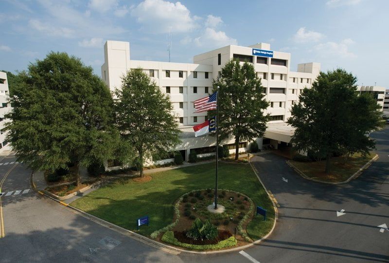 Hospital building with US and North Carolina flags waving.