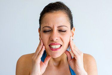 Woman touching her Jawbone .