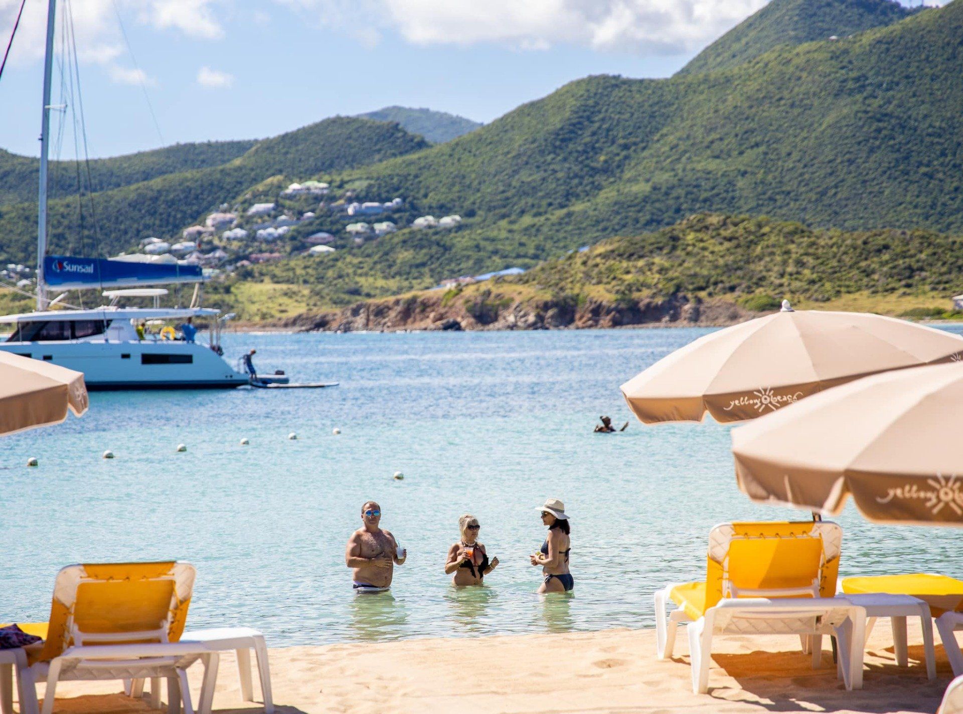A group of people are swimming in the ocean on a beach.