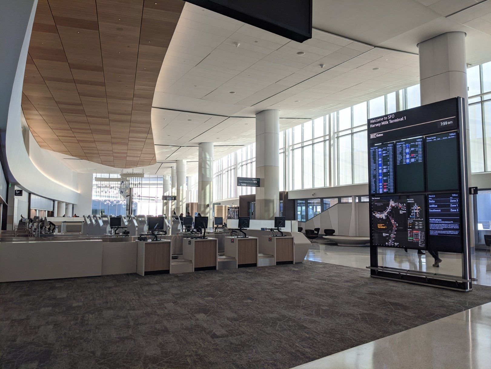 A carpeted check in area within Harvey Milk terminal stands empty.