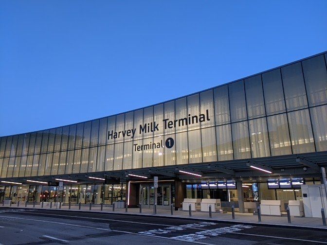 The outside of the Harvey Milk Terminal against a blue night sky.