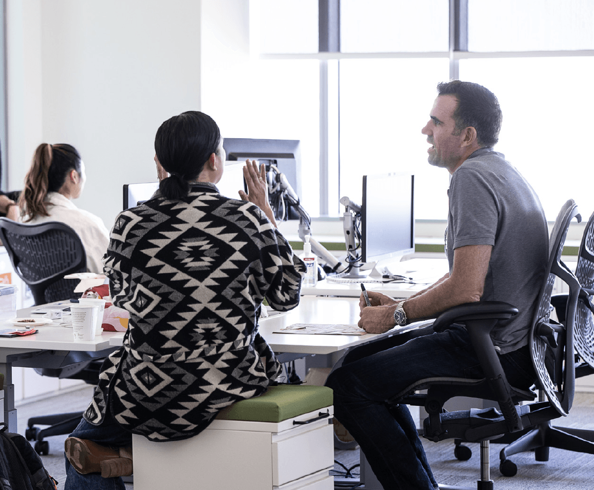 Two coworkers converse with faces hidden, from Genentech Campus Plan 2019 PDF.
