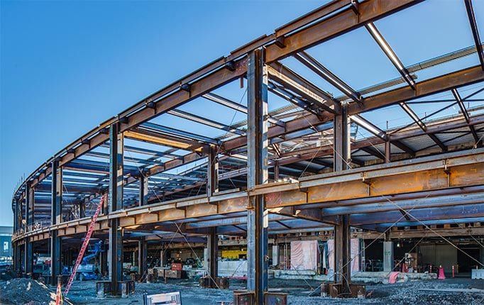 An in-progress large structure, with the view showing the initial metal construction of the building at an angle.